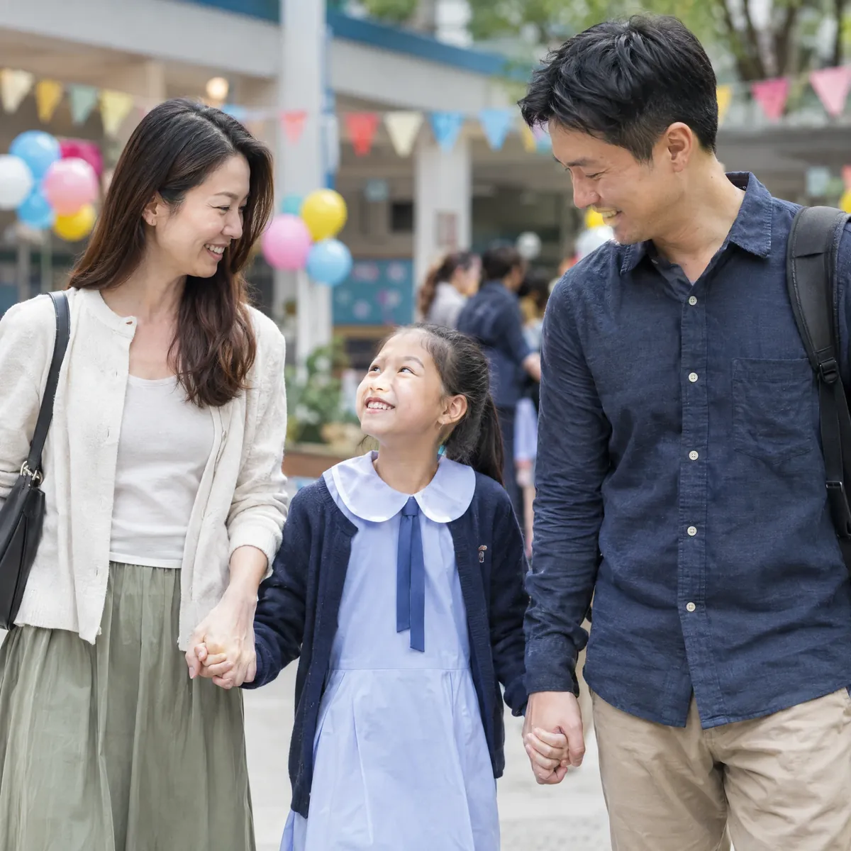 爸媽一同出席家長日，孩子站在中間